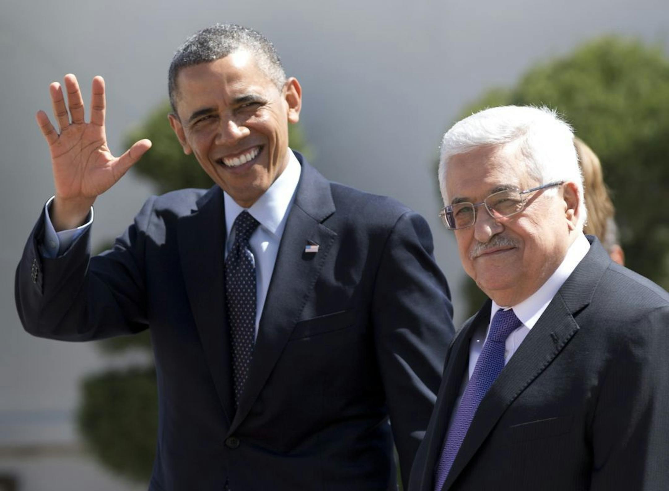 President Barack Obama waves to media as he walks with Palestinian President Mahmoud Abbas, right, as he arrives at the Muqata Presidential Compound Thursday, March 21, 2013, in the West Bank town of Ramallah.