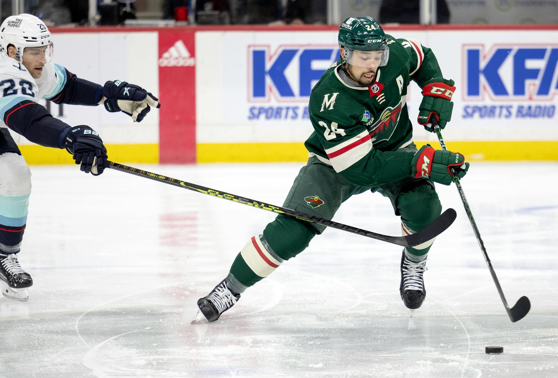 Carson Soucy (28) of the Seattle Kraken and Matt Dumba (24) of the Minnesota Wild battle for the puck in the second period.