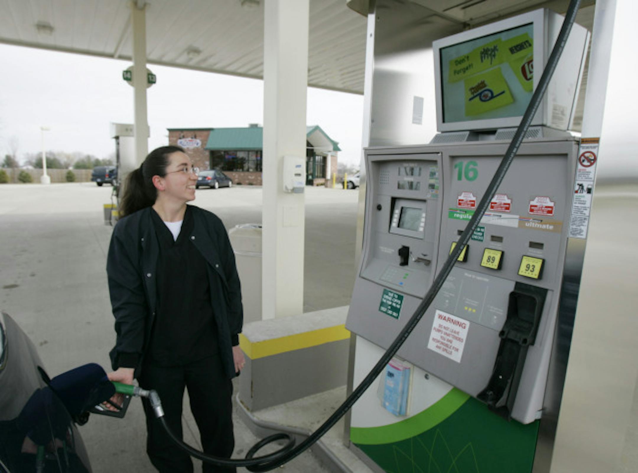 Christy Ridenour fuels her car while watching the television placed atop a gas pump at the BP Gas Station in Anderson, Ind., Wednesday, March 26, 2008. Ridenour noted she enjoys watching the area weather forecast and traffic reports. Ricker Oil Co. President Jay Ricker, operator of this station and 29 others throughout Indiana, is experimenting with the pump-top televisions advertising goodies inside the station's store.
