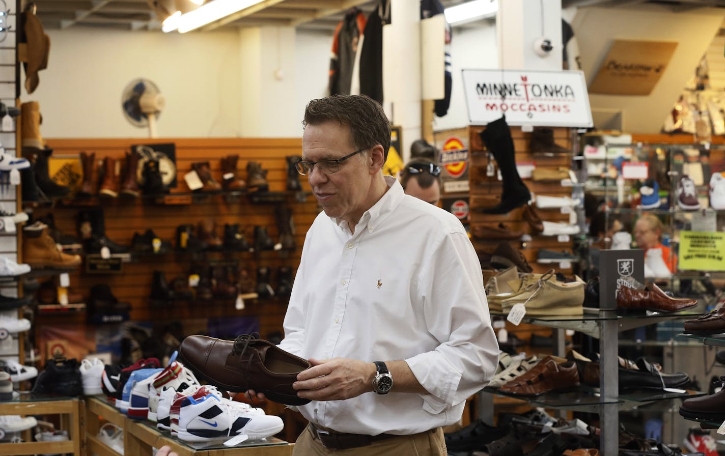 Mark Simon owner of Roberts Shoe store help a customer at the store Monday August 4 , 2014 in Minneapolis , MN . Roberts Shoe store a mainstay at Chicago and Lake street is is closing after 77 years .] Jerry Holt Jerry.holt@startribune.com