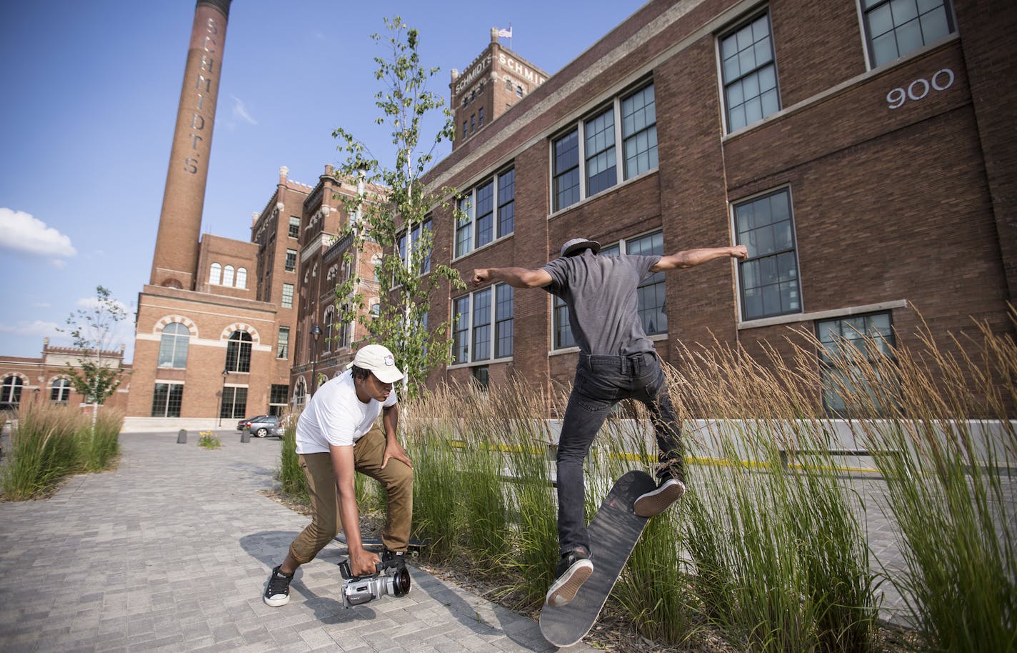 Drey Standberry, 17, films Repolia Robinson, 17, doing skateboarding tricks in front of Schmidt Artist Lofts in St. Paul on Thursday, July 9, 2015. ] LEILA NAVIDI leila.navidi@startribune.com /