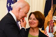President Joe Biden speaks with Sen. Amy Klobuchar (D-Minn.) after signing H.R. 1652, the VOCA Fix to Sustain the Crime Victims Fund Act of 2021, into