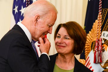 President Joe Biden speaks with Sen. Amy Klobuchar (D-Minn.) after signing H.R. 1652, the VOCA Fix to Sustain the Crime Victims Fund Act of 2021, into