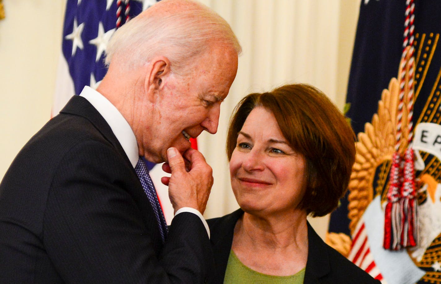 President Joe Biden speaks with Sen. Amy Klobuchar (D-Minn.) after signing H.R. 1652, the VOCA Fix to Sustain the Crime Victims Fund Act of 2021, into law at The White House in Washington on July 22, 2021. Vice President Kamala Harris is at left. (Kenny Holston/The New York Times)