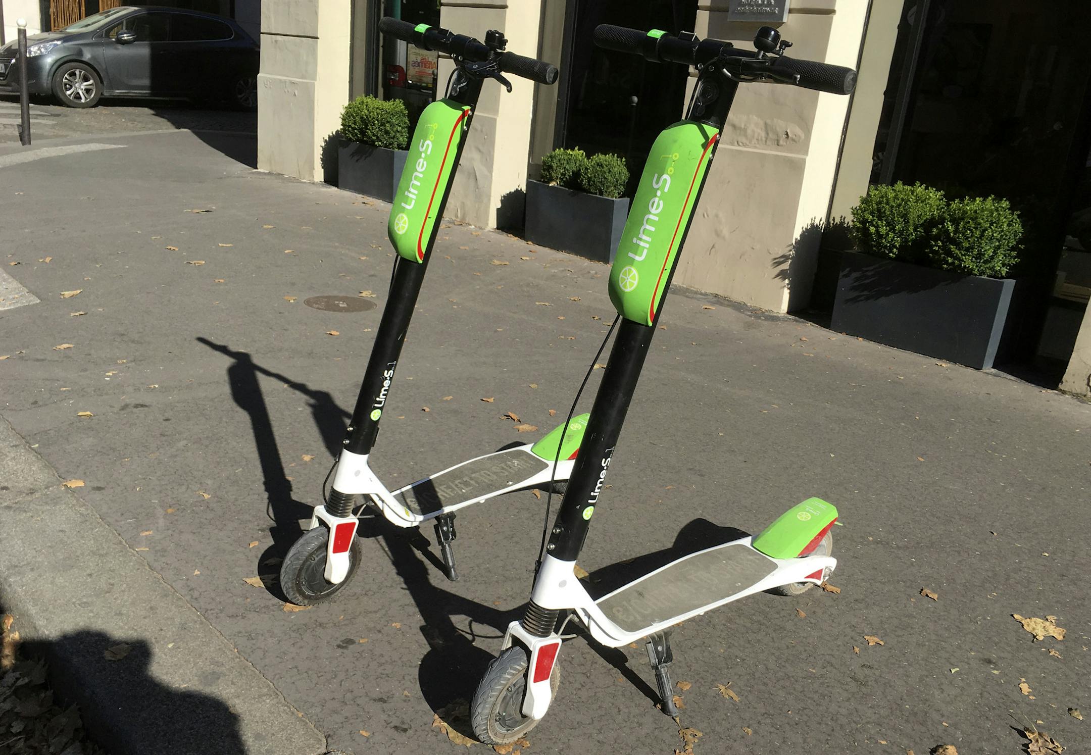 This July 3, 2018, photo shows scooters by Lime in Paris. Uber is getting into the scooter-rental business. The ride-hailing company said Monday, July 9, that it is investing in Lime, a startup based in San Mateo, California. (AP Photo/Michel Euler)