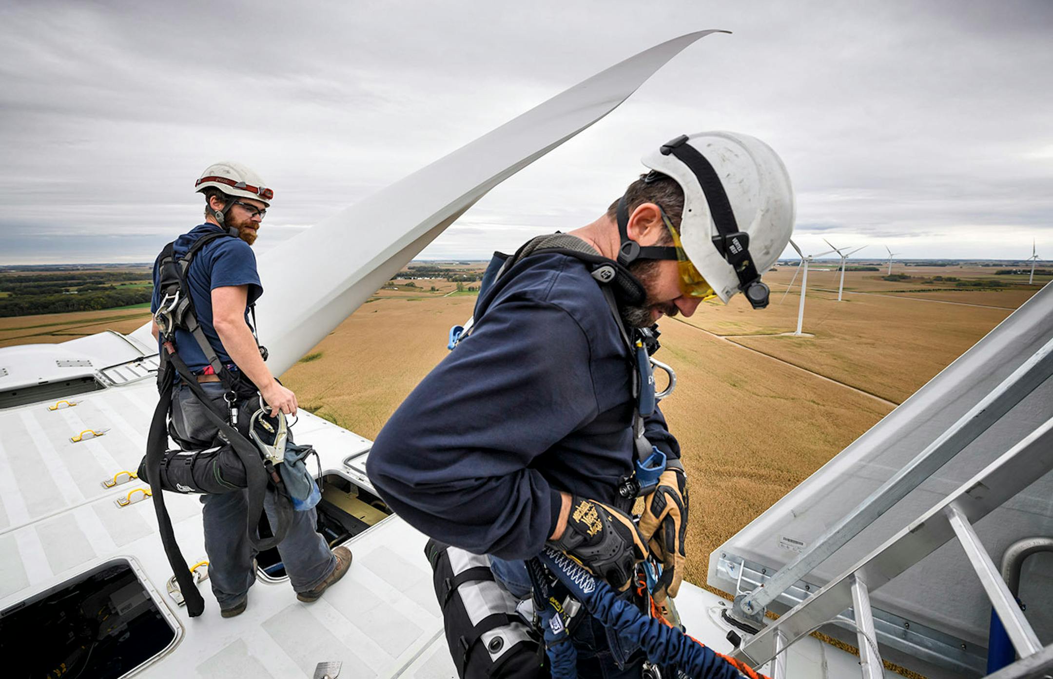 Atop the nacelle of a Vestas wind turbine, 300 feet in the air, Shane Keck and Will Osborn checked their own and each other's safety gear before descending to the ground after servicing a wind sensor that was out of alignment.