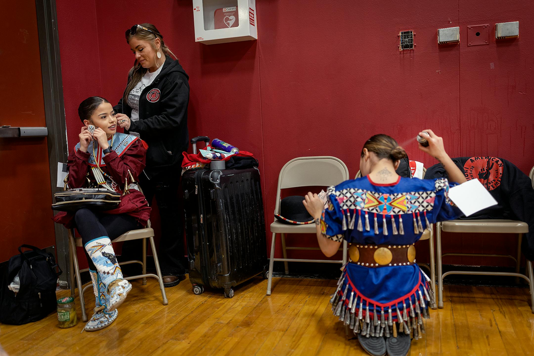 Caylee White Eagle, left, and Tarah White Eagle get help from their mother Wambli Ska as they get ready for a Pow Wow to honor the AIM Warriors of Wounded Knee of 1973 in Wanblee, SD on the Pine Ridge Indian Reservation.