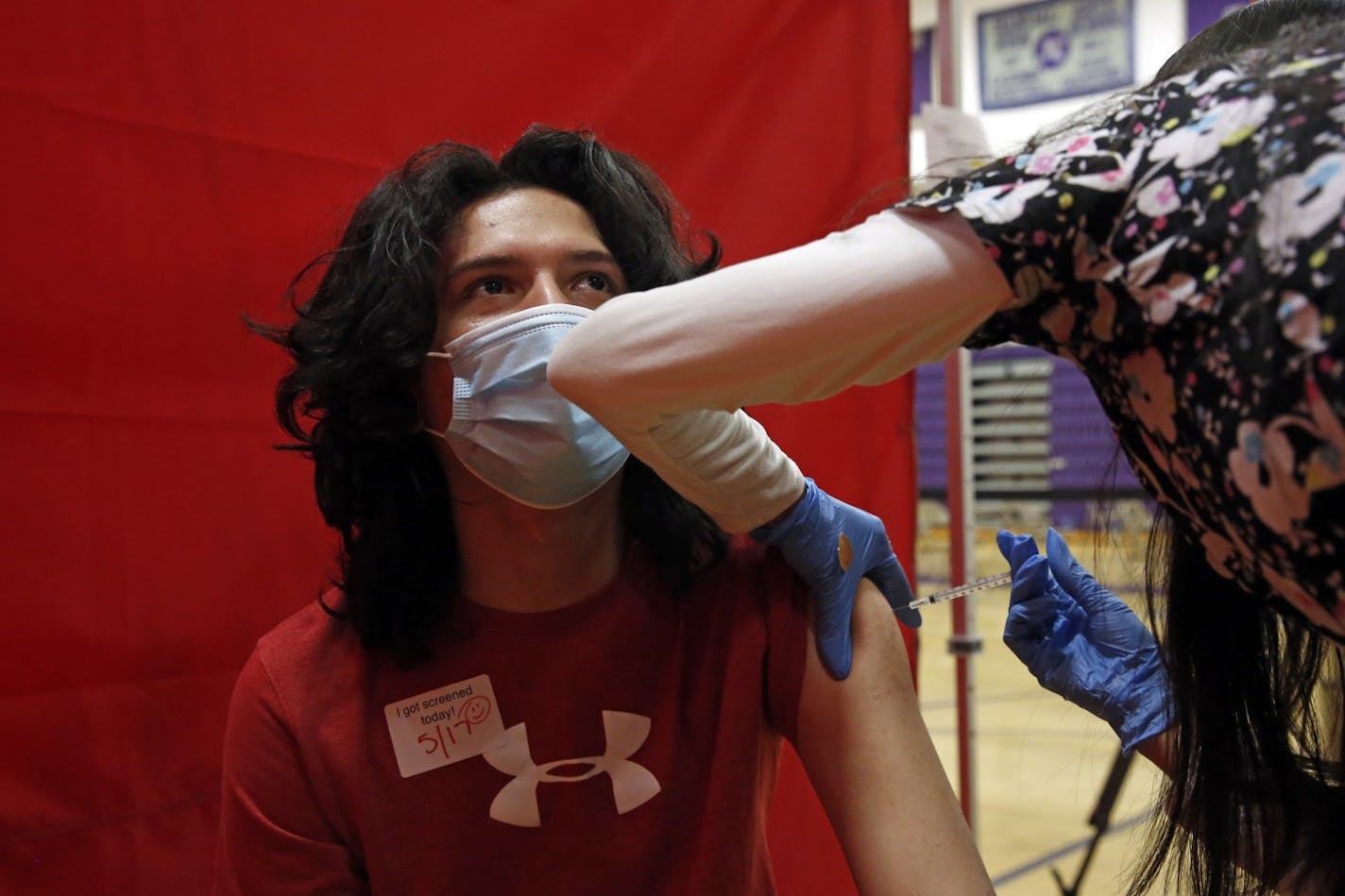 Aragon Leep, 17, is vaccinated with Pfizer at the Manual Arts High School basketball and gym building in downtown on Monday, May 17, 2021 in Los Angeles, CA. The school is one of 200 sites that the Los Angeles Unified School District has deployed mobile vaccination teams to get as many shots into students' arms as possible. (Dania Maxwell / Los Angeles Times/TNS) ORG XMIT: 16833222W