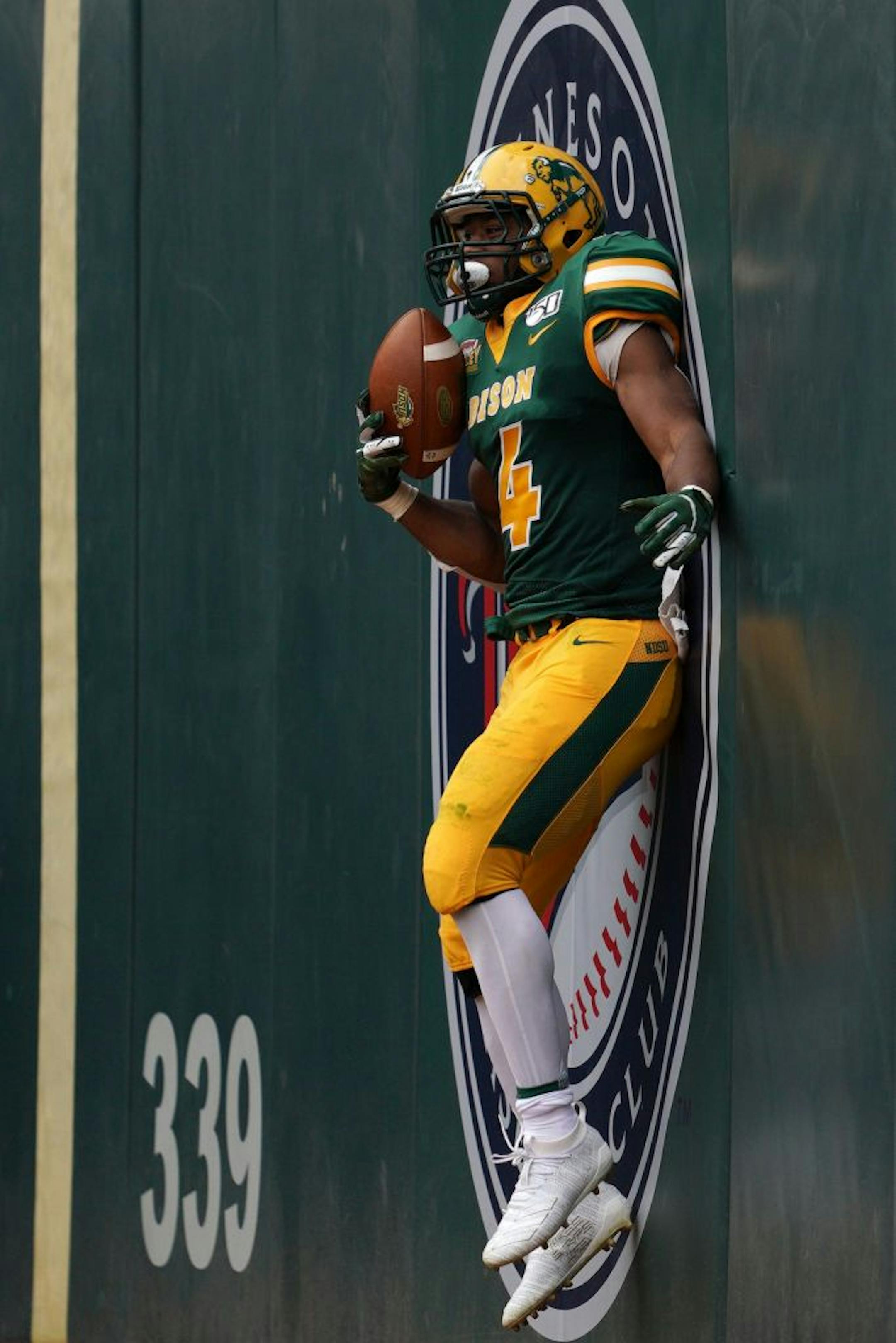 North Dakota State Bison running back Dimitri Williams (4) threw himself against the Minnesota Twins logo after he scored a touchdown in the first half.