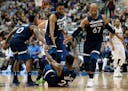 Minnesota Timberwolves' Jeff Teague (0), Karl-Anthony Towns (32) and Taj Gibson help Jimmy Butler (23) off the floor during an NBA basketball game aga