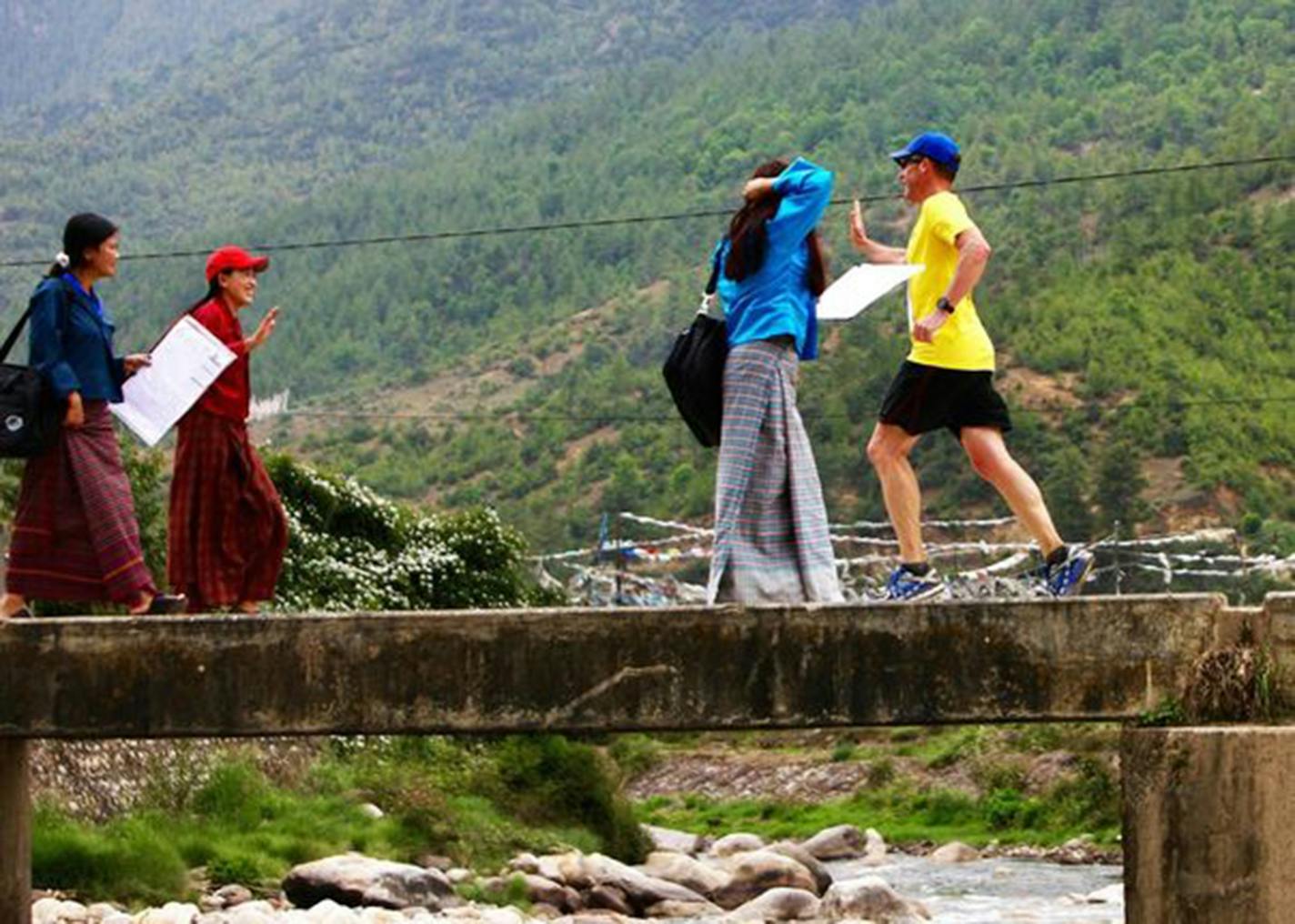 Marathon Tours and Travel President Jeff Adams (in yellow) gets a high five during the Bhutan Thunder Dragon Marathon, a race that traverses spectacular mountain scenery in this elusive Himalayan kingdom. The next one is May 27, 2018. (Marathon Tours and Travel)