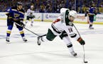 Minnesota Wild's Justin Fontaine, right, shoots as St. Louis Blues' Steve Ott, left, watches during the first period in Game 1 of an NHL hockey first-