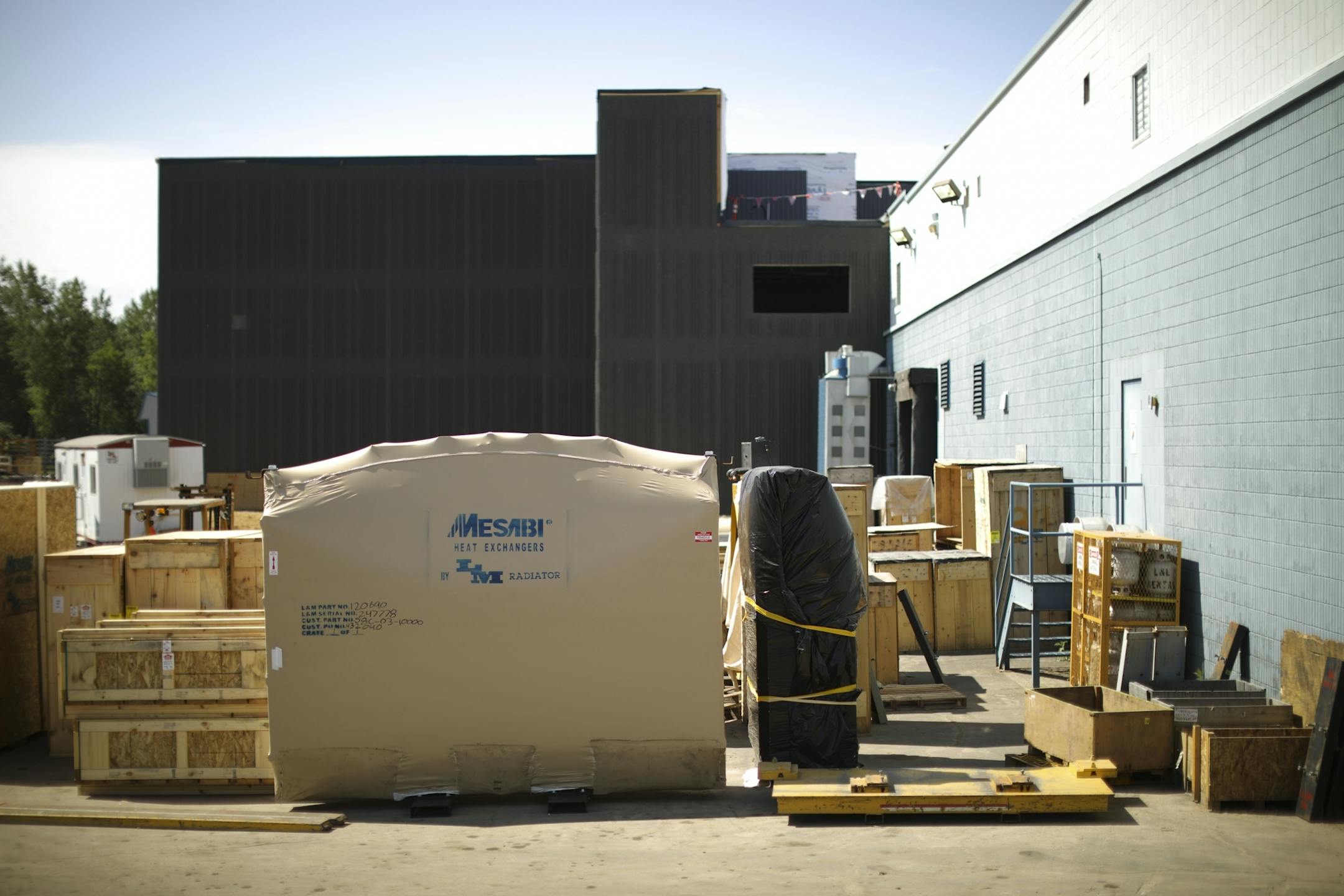 A portion of the new expansion under construction, rear, dwarfs the current manufacturing facility of L & M Radiators in Hibbing.
