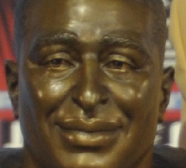 Hall of Fame inductee Cris Carter poses with his bust during the 2013 Pro Football Hall of Fame Induction Ceremony Saturday, Aug. 3, 2013, in Canton, 
