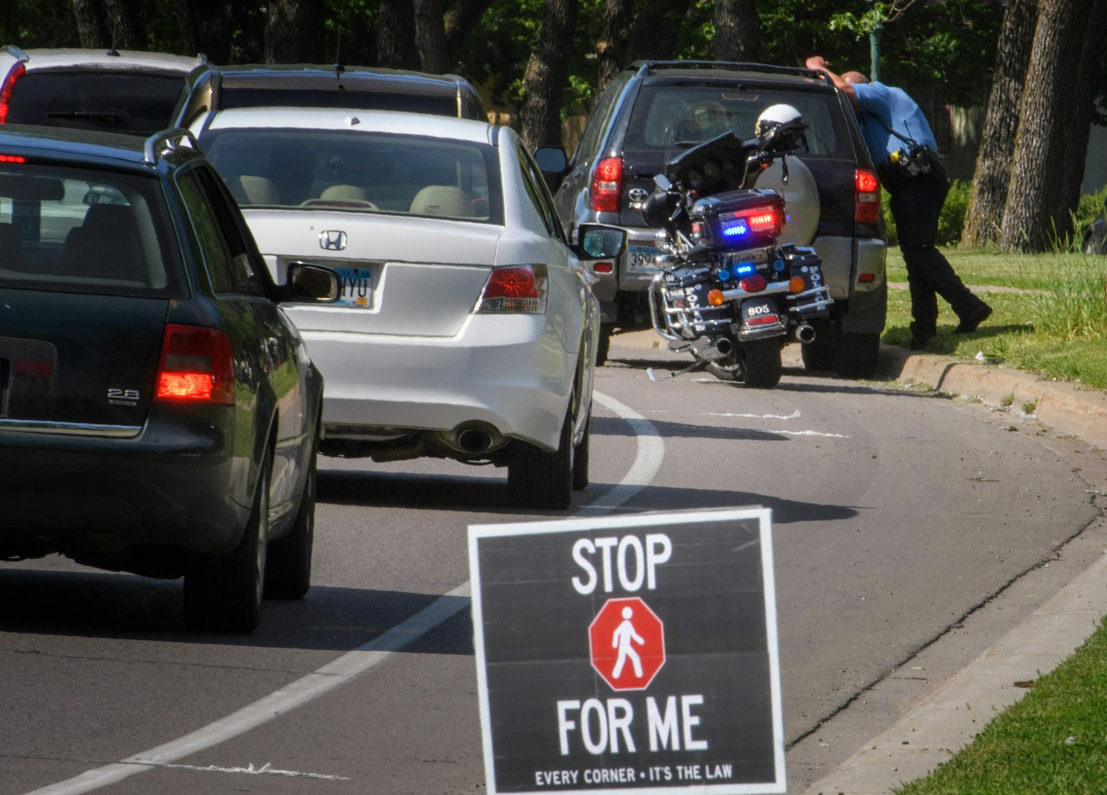 A blue Toyota SUV drove through the marked crosswalk in front of pedestrian volunteers. It was pulled over seconds later by St. Paul Police. ] GLEN STUBBE * gstubbe@startribune.com Wednesday, June 8, 2016, Volunteers from neighborhood groups working with StopForMe.org entered a marked pedestrian crosswalk at Johnson Parkway and Ames Ave on the East Side of St. Paul. If the vehicles violated the law they were pulled over by St. Saul Police. A day after yet another pedestrian was killed after bein