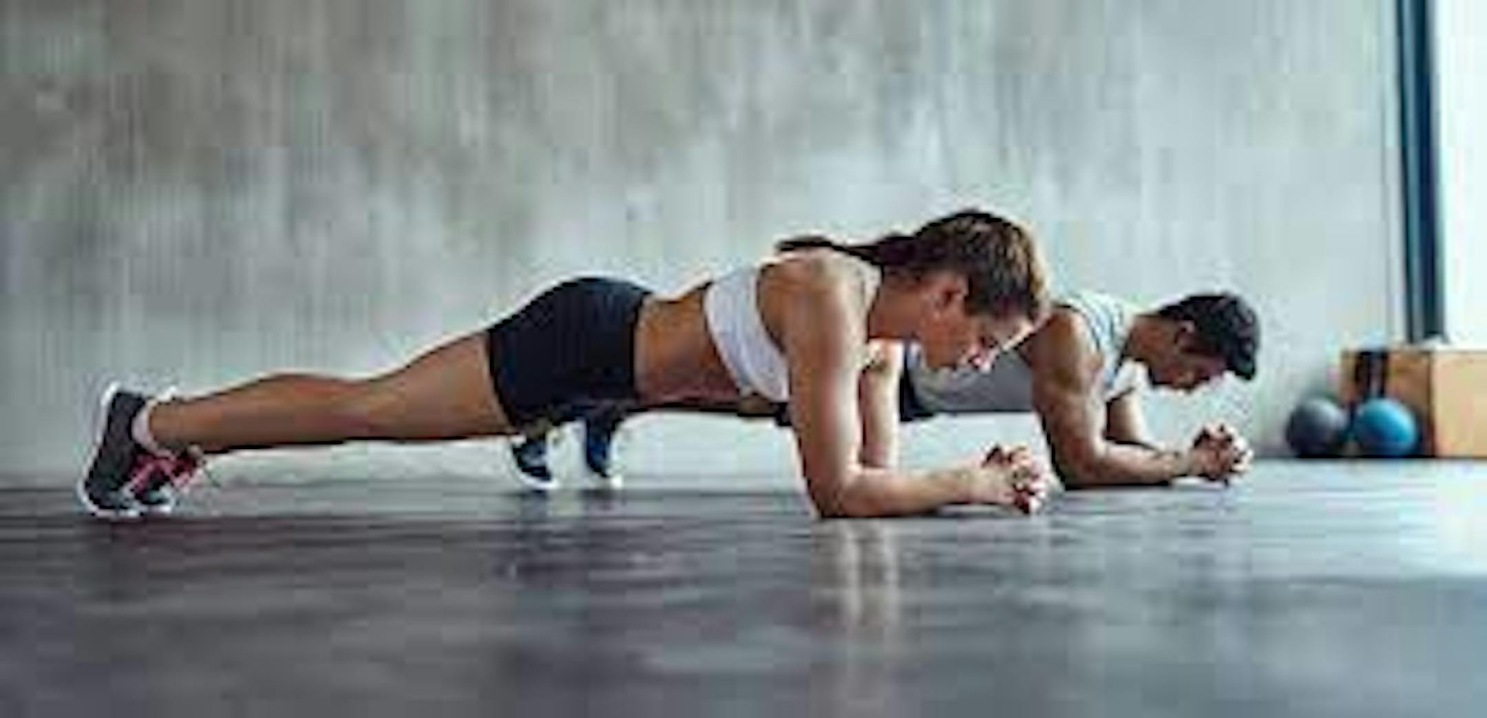 Two people demonstrate a plank.