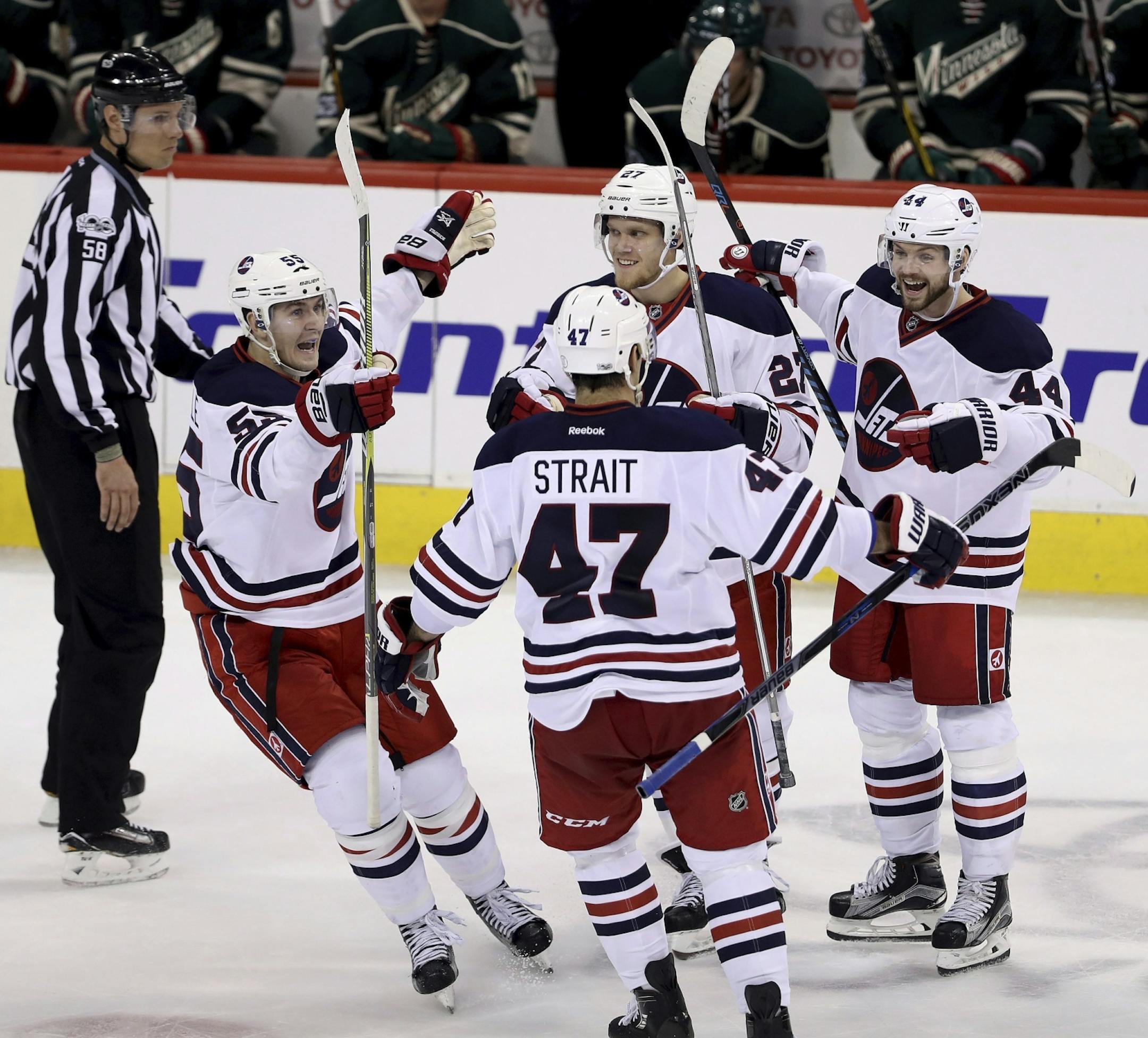 Winnipeg Jets' Mark Scheifele (55), Brian Strait (47), Nikolaj Ehlers (27) and Josh Morrissey (44) celebrate after Morrissey scored against the Minnesota Wild during the third period of an NHL hockey game in Winnipeg, Manitoba, Sunday, March 19, 2017.
