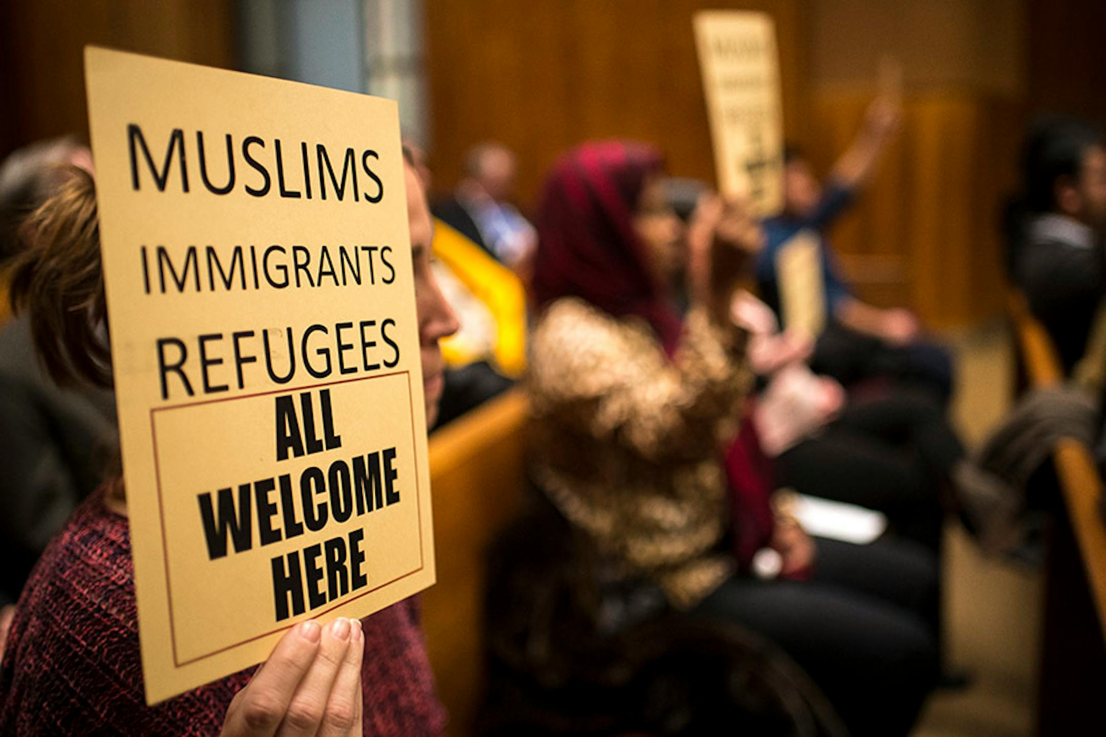 Sarah Lechowich, of St. Paul, held a sign voicing her support for a city council resolution condemning Republican presidential candidate Donald Trump for anti-Muslim, anti-refugee and anti-immigrant speech Wednesday night.
