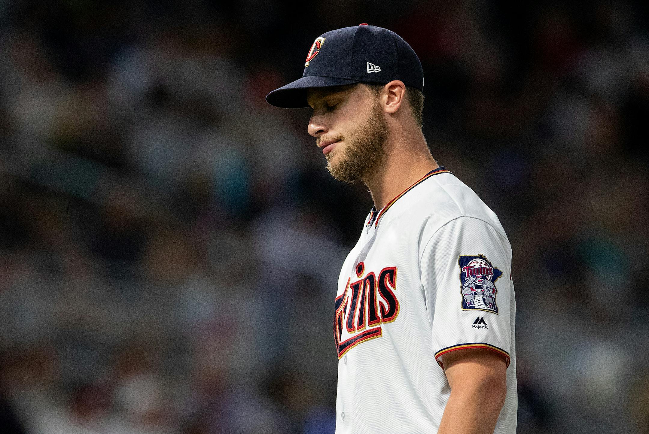 Twins pitcher Alan Busenitz walked to the dugout after being pulled from the game in the seventh inning.