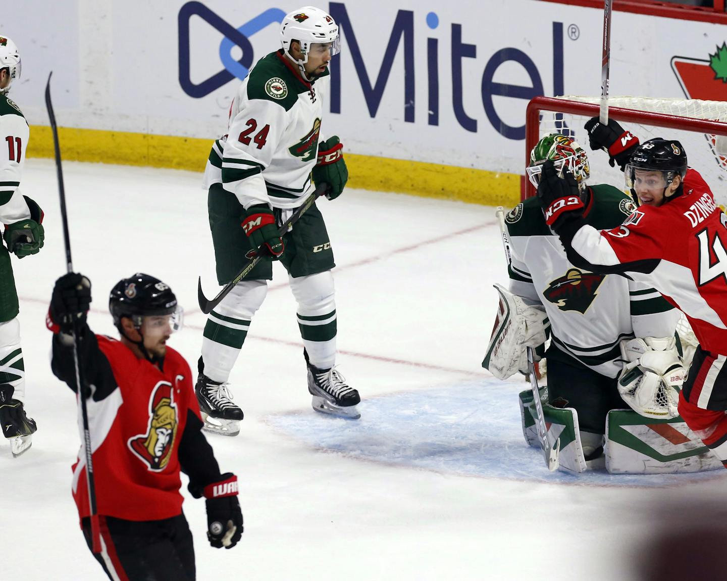 Minnesota Wild goaltender Devan Dubnyk (40) and teammate Matt Dumba (24) react as Ottawa Senators' Erik Karlsson, front left, celebrates his overtime goal with teammate Ryan Dzingel (43) in an NHL hockey game Tuesday, March 15, 2016, in Ottawa, Ontario. (Fred Chartrand/The Canadian Press via AP)