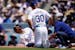 Los Angeles Dodgers' Mookie Betts, left, writhes on the ground after being hit by a pitch as manager Dave Roberts and a trainer tend to him during the