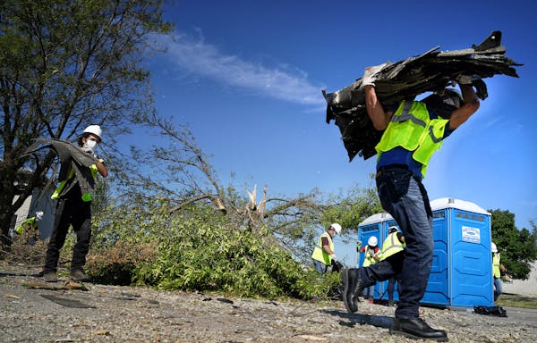 Neighbors, volunteers and contract workers from Blue Sky Restoration cleaned up debris from last week's derecho that ripped through Cedar Rapids.