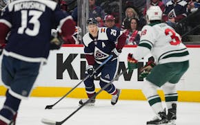 Avalanche center Nathan MacKinnon (29) handles the puck against the Wild in Denver on Tuesday. MacKinnon had a hat trick before the end of the second 