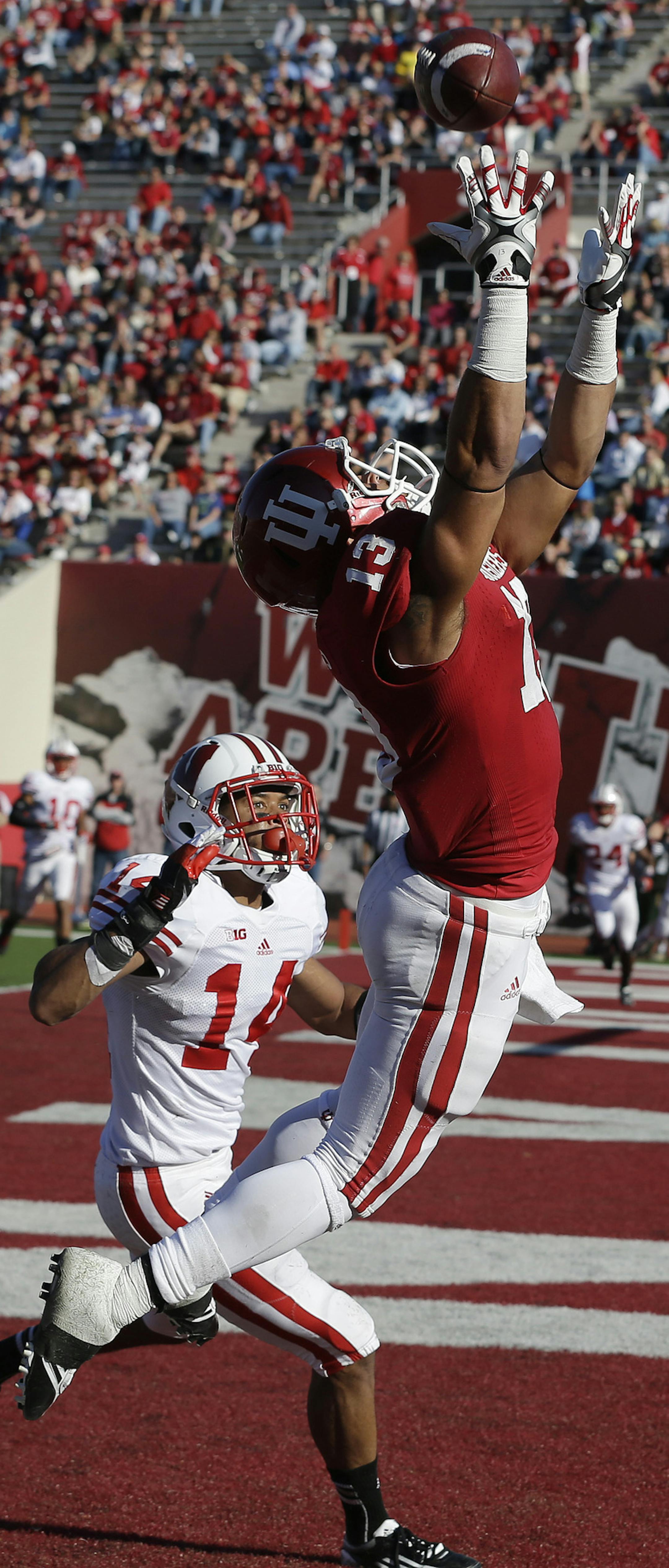 Indiana's Kofi Hughes (13) makes a 7-yard touchdown reception while while being defended by Wisconsin's Marcus Cromartie during the second half of an NCAA college football game Saturday, Nov. 10, 2012, in Bloomington, Ind. Wisconsin defeated Indiana 62-14.(AP Photo/Darron Cummings) ORG XMIT: BLS116
