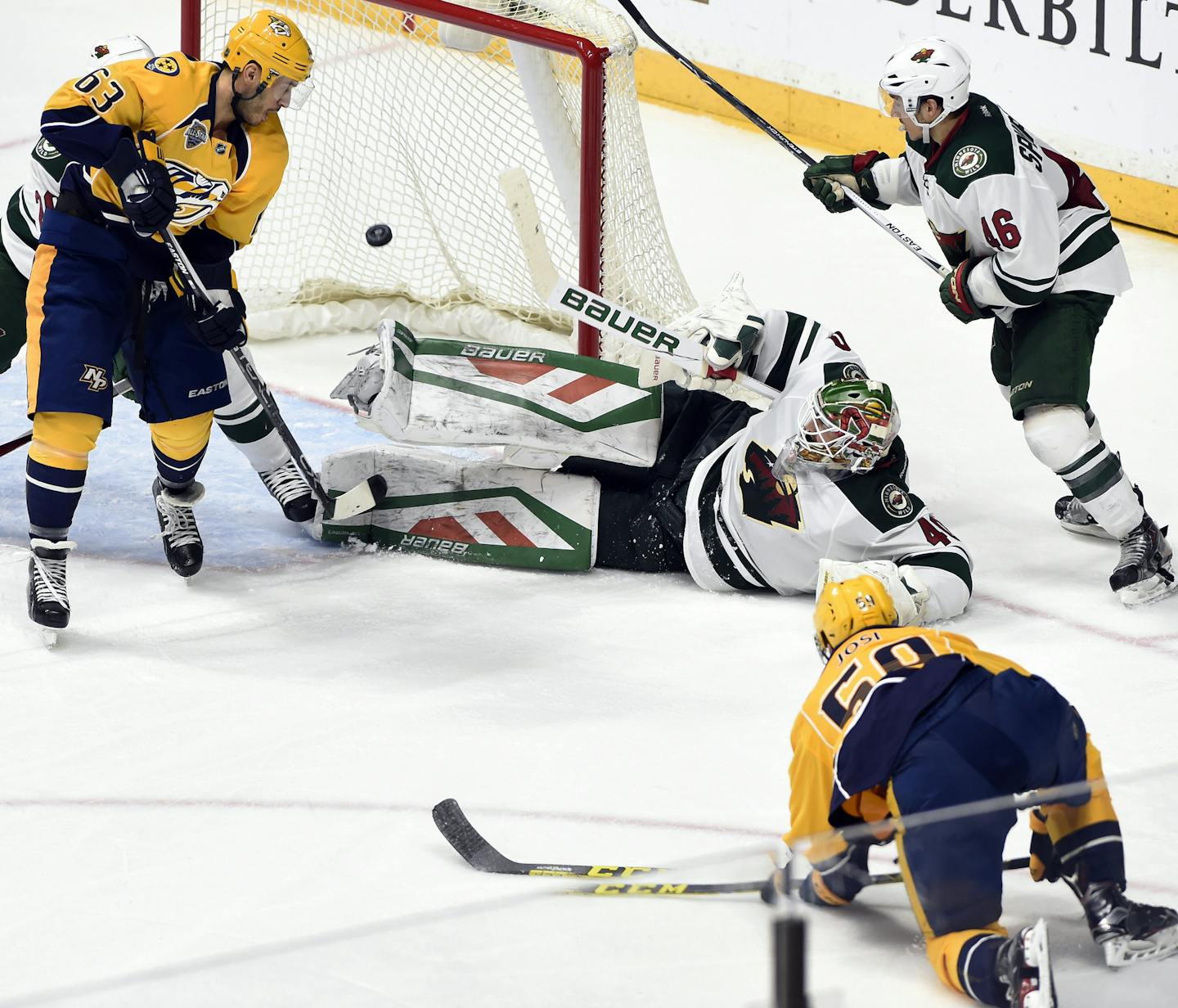 Nashville Predators defenseman Roman Josi, of Switzerland, bottom right, scores a goal against Minnesota Wild goalie Devan Dubnyk (40) as Predators' Mike Ribeiro (63) and Wild defenseman Jared Spurgeon (46) watch the puck during the third period of an NHL hockey game Saturday, Jan. 16, 2016, in Nashville, Tenn. The Predators won 3-0. (AP Photo/Mark Zaleski)