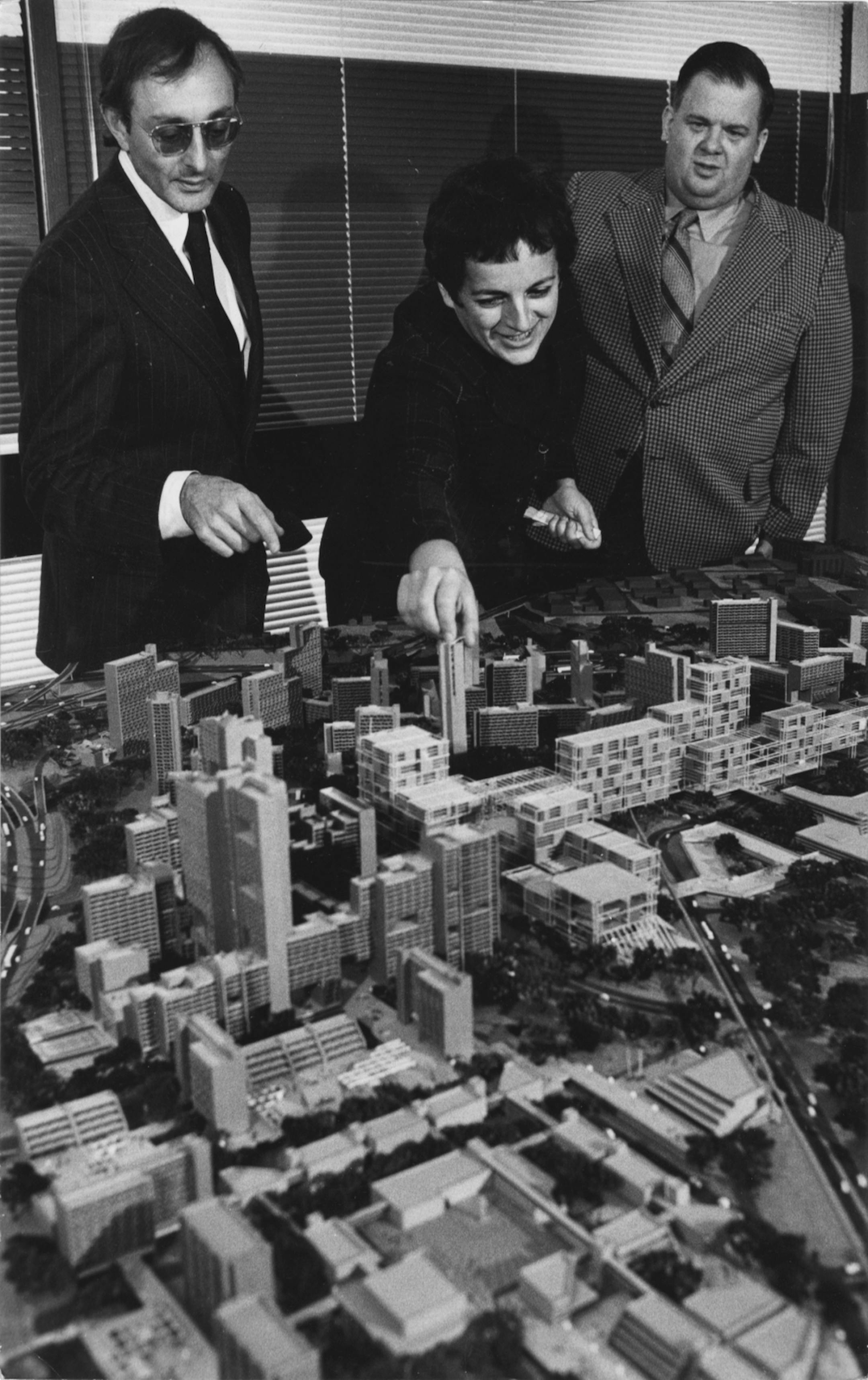 Model of completed Cedar-Riverside, Gloria Segal (center), Sheldon Lubar (left) and Keith Heller(right).