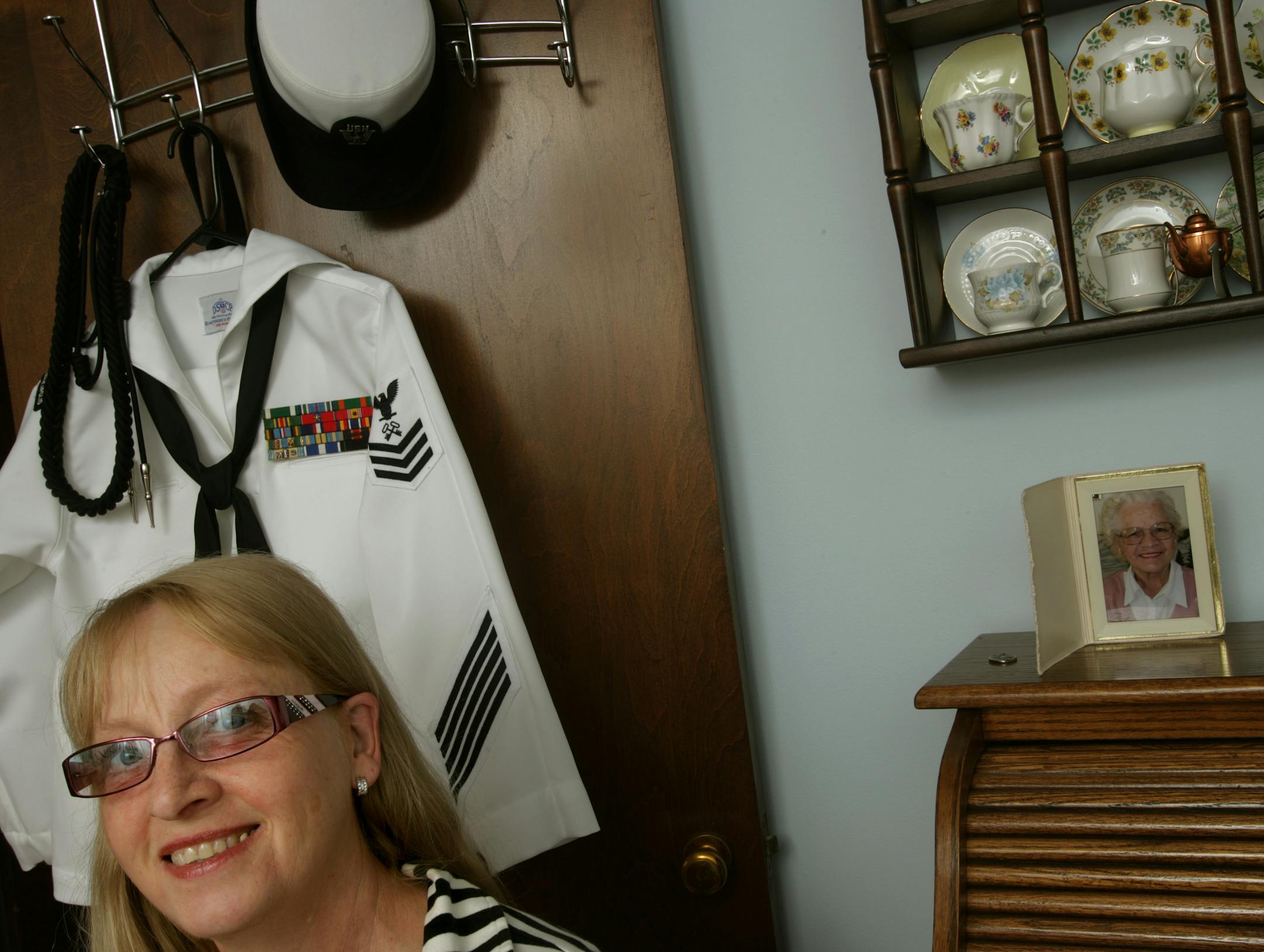 In the room that was her brother's, then a sewing room, then a dining room, Laurie Volkmuth-McNutt posed with her Navy uniform, her mother's desk and a collection of teacups owned by her mom and grandmother.