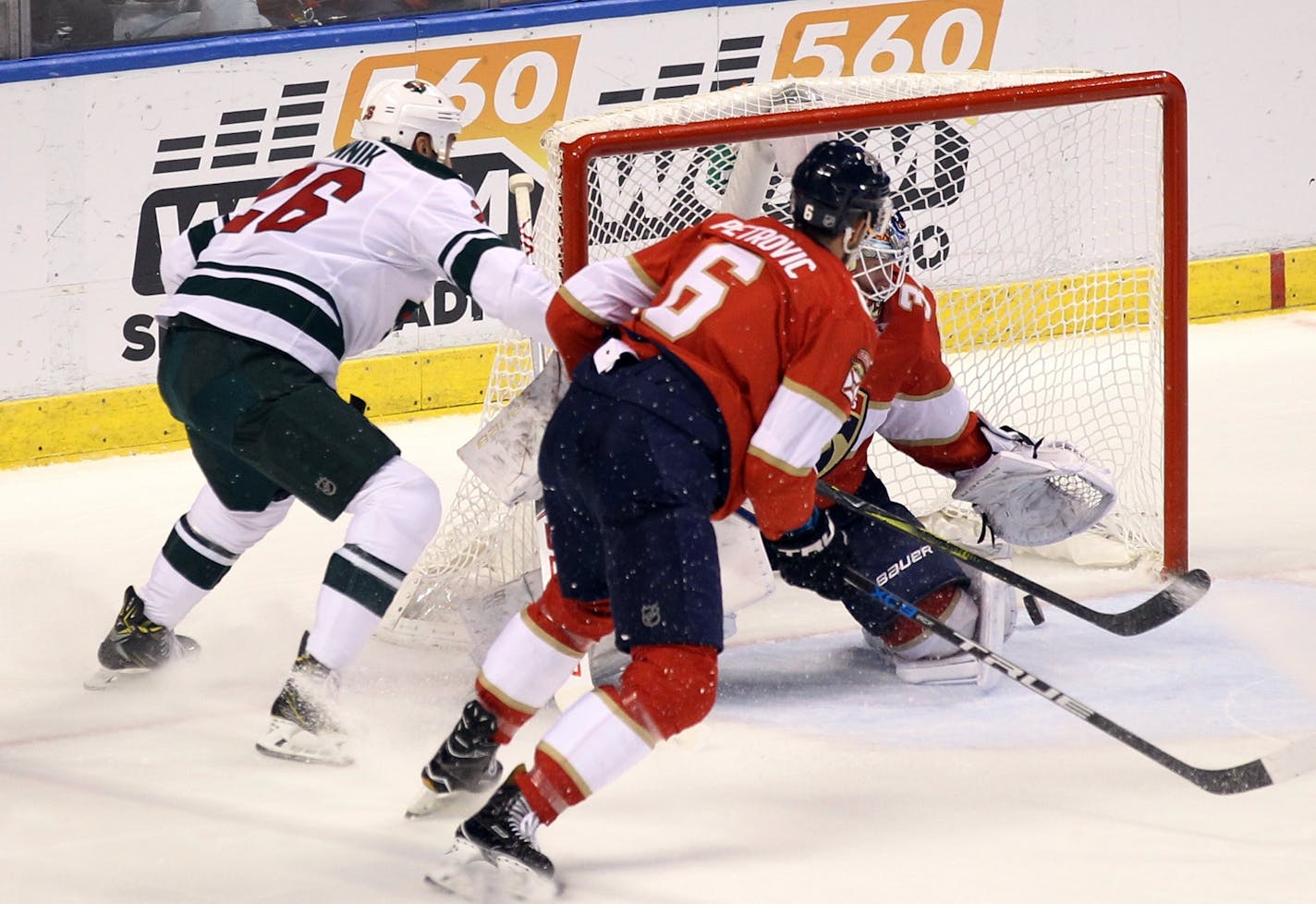 Minnesota Wild's Daniel Winnik, left, scores a goal against Florida Panthers goalie James Reimer as Panthers' Alex Petrovic (6) defends during the second period of an NHL hockey game, Friday, Dec. 22, 2017, in Sunrise, Fla. (AP Photo/Luis M. Alvarez)