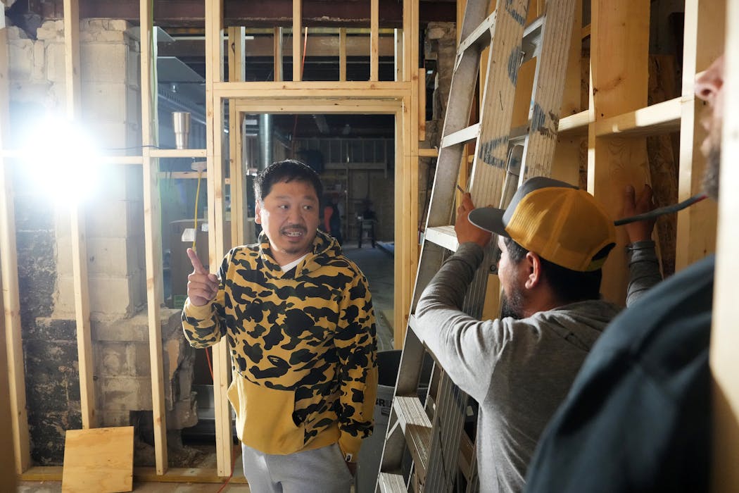 Rob Yang talks with workers as he looks over construction on his University Avenue property.