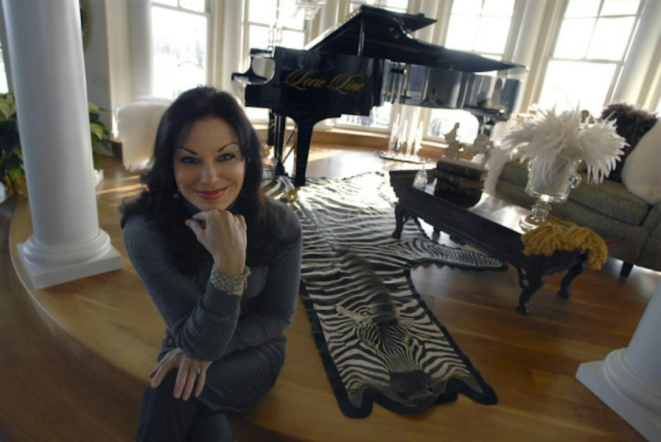 Lorie Line with one of her pianos during a tour of the house several years ago.