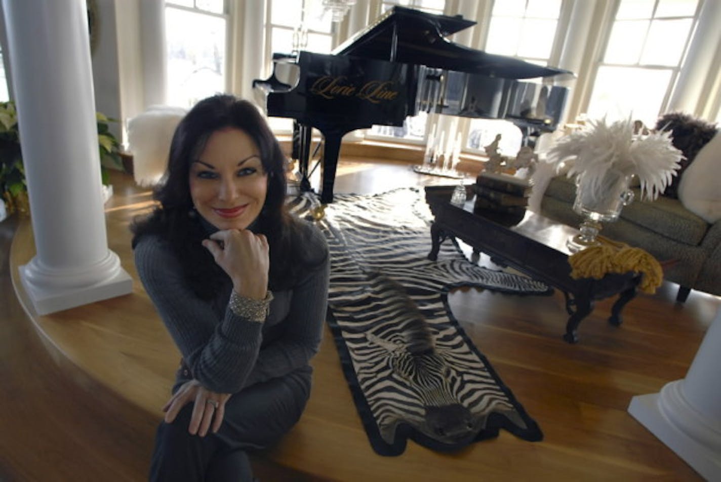 Lorie Line with one of her pianos during a tour of the house several years ago.