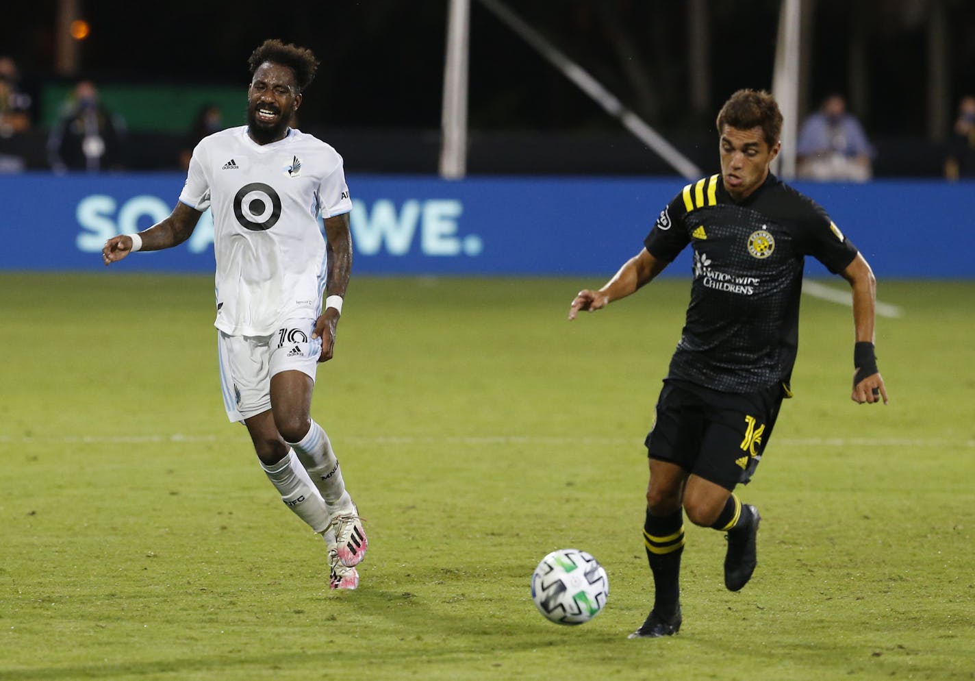 Minnesota United defender Romain Metanire (19) had to leave the game after he slowed down and grabbed his hamstring while Columbus Crew midfielder Hector Jimenez (16) runs away with the ball during the second half of an MLS soccer match in Kissimmee, Fla., Tuesday, July 28, 2020. (AP Photo/Reinhold Matay)