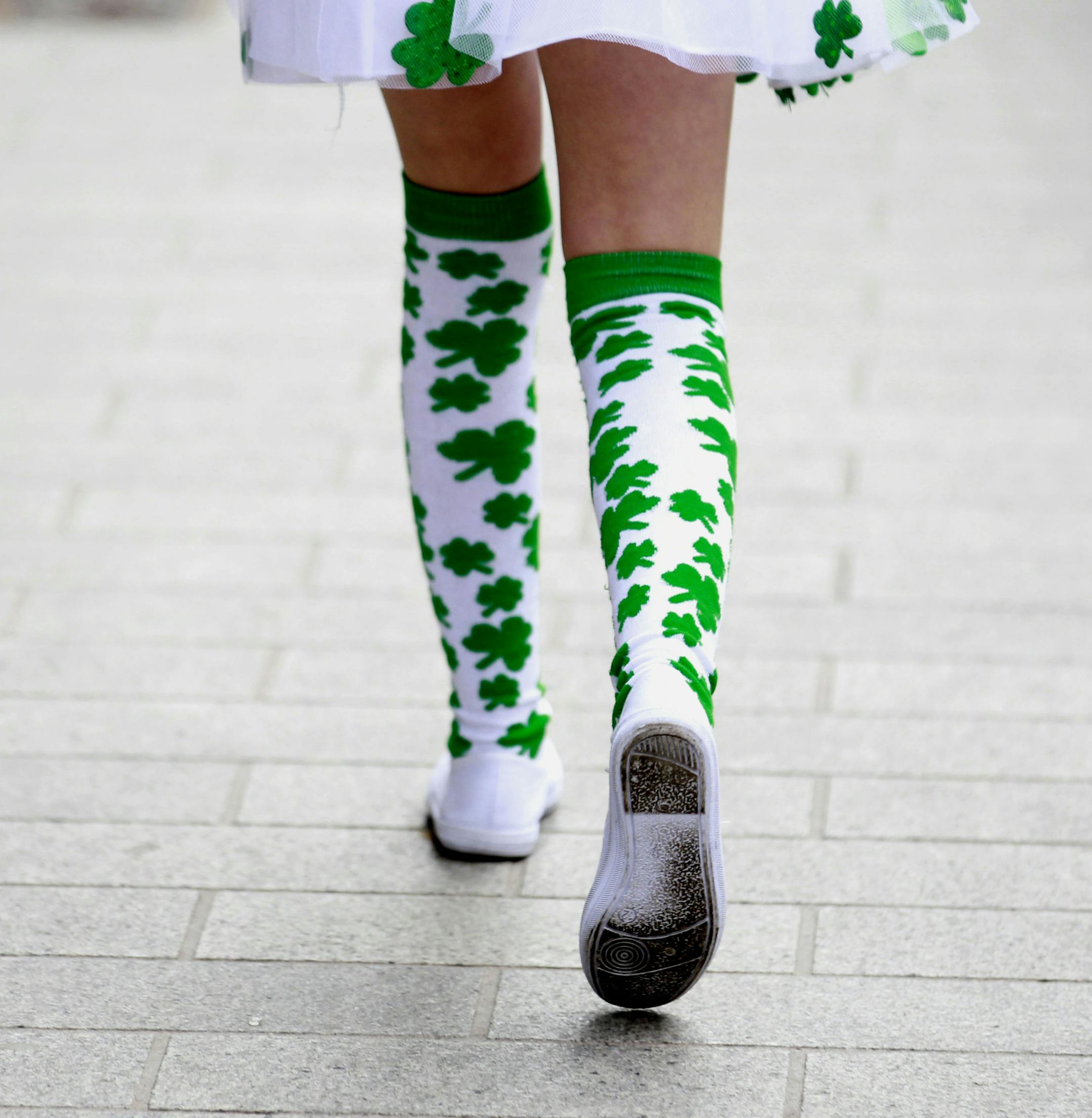 A girl with shamrock tights joins in the St Patrick's Day celebrations in Belfast, Northern Ireland, Thursday, March, 17, 2011. St Patrick's Day is celebrated every 17 March, with revelers sporting green attire, drinking Dublin's famous black brew Guinness, listening to traditional music and attending parades in honor of the saint who played an important role in converting Ireland to Christianity. (AP Photo/Peter Morrison)