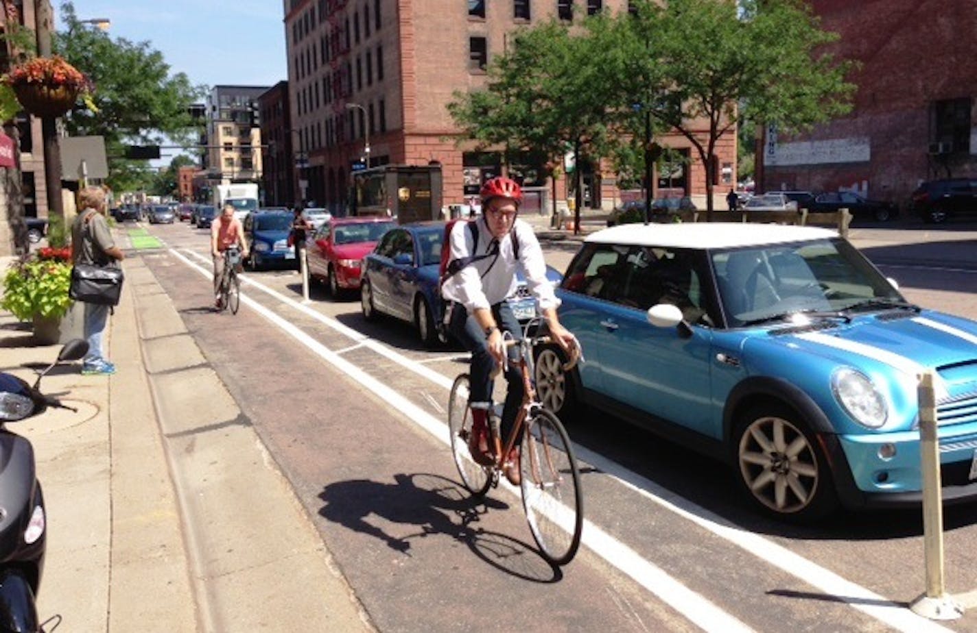 Bikers use a protected bike lane on 1st Avenue N. that's between the curb and parked cars.