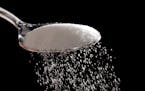 Granulated sugar is poured in Philadelphia, Monday, Sept. 12, 2016. A new study released Monday details how the sugar industry worked to downplay emer