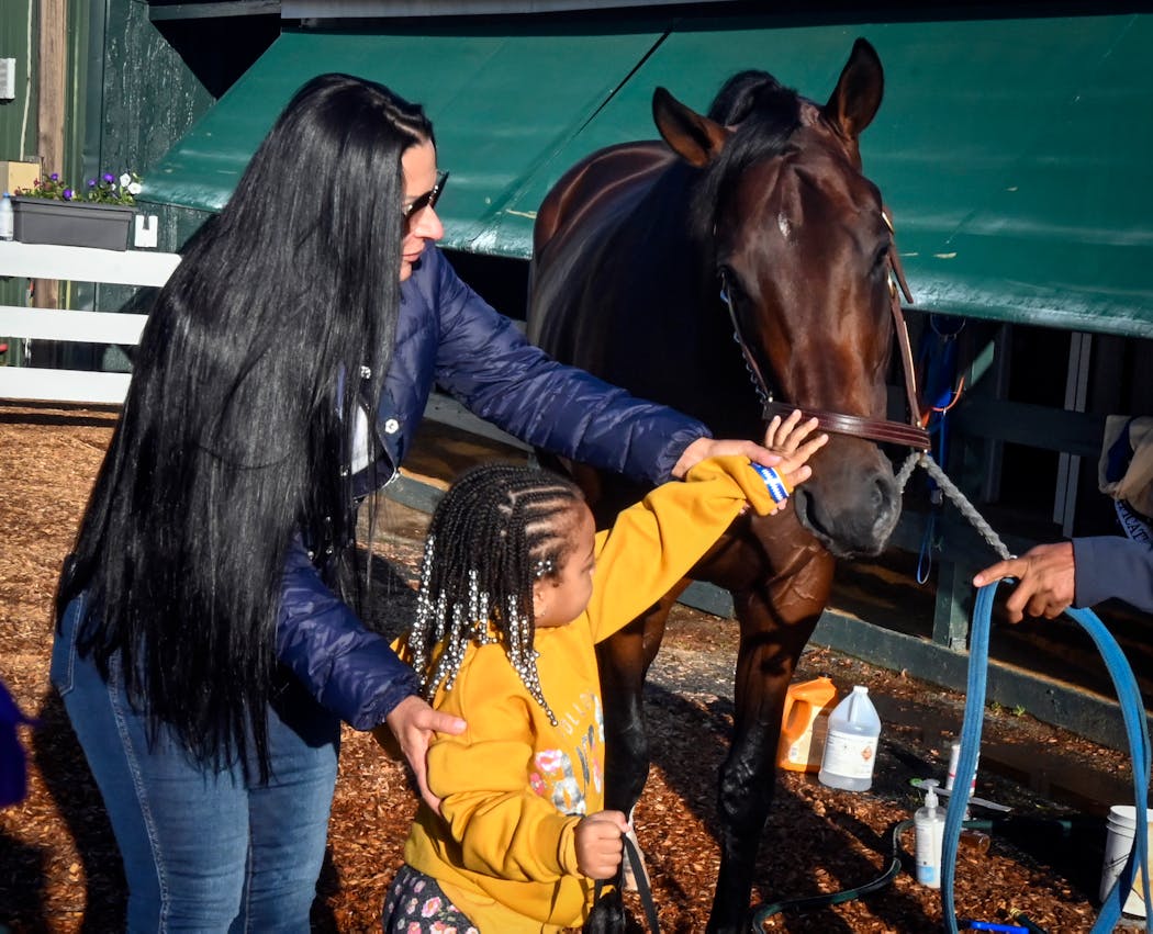 Lovely Brown, 4, meets Preakness contender Simplification with the assistance of the horse’s owner Tami Bobo on Tuesday.