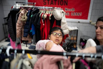 Twelfth-grader Anna Wagner adds a new winter coat to a rack at the Eagle Nation Station, a free pantry offering food, school supplies, personal hygien