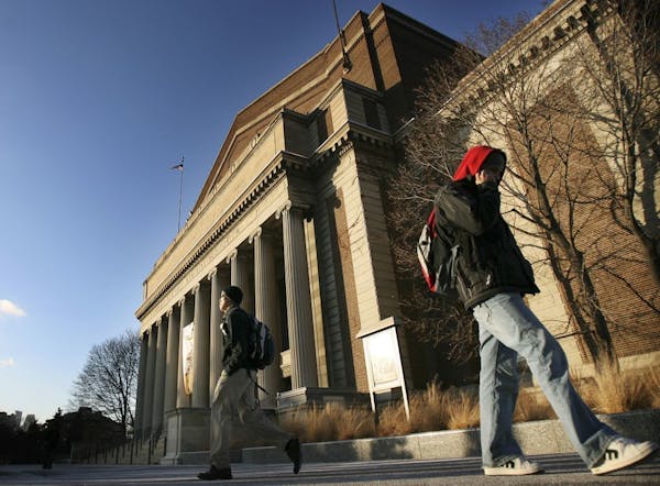 Students walk pass Northrop Auditorium on the University of Minnesota campus.