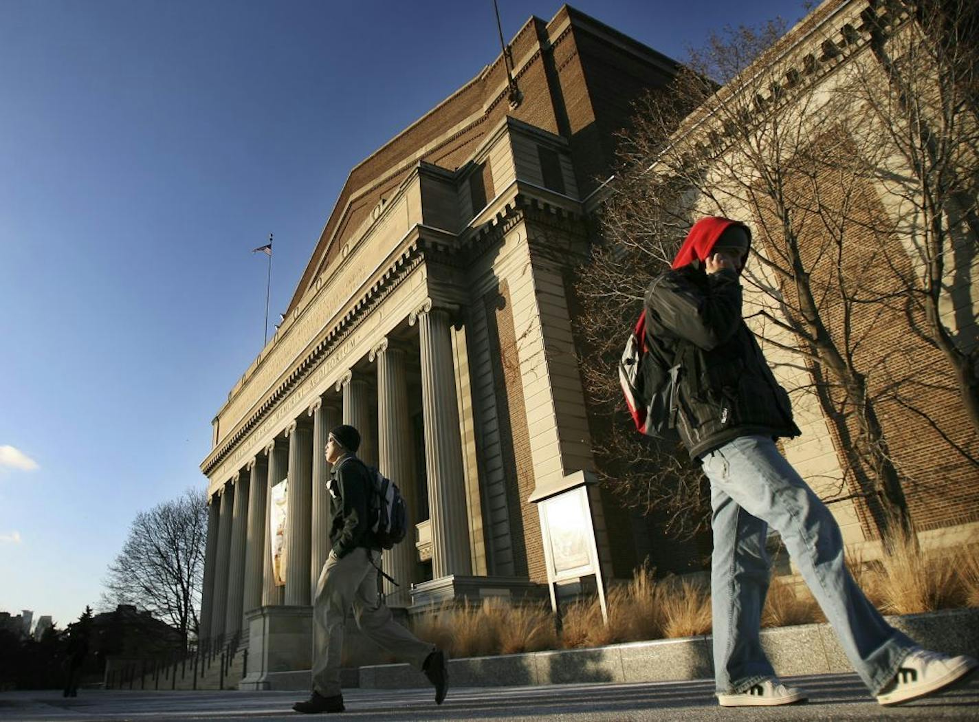 Students walk pass Northrop Auditorium on the University of Minnesota campus.