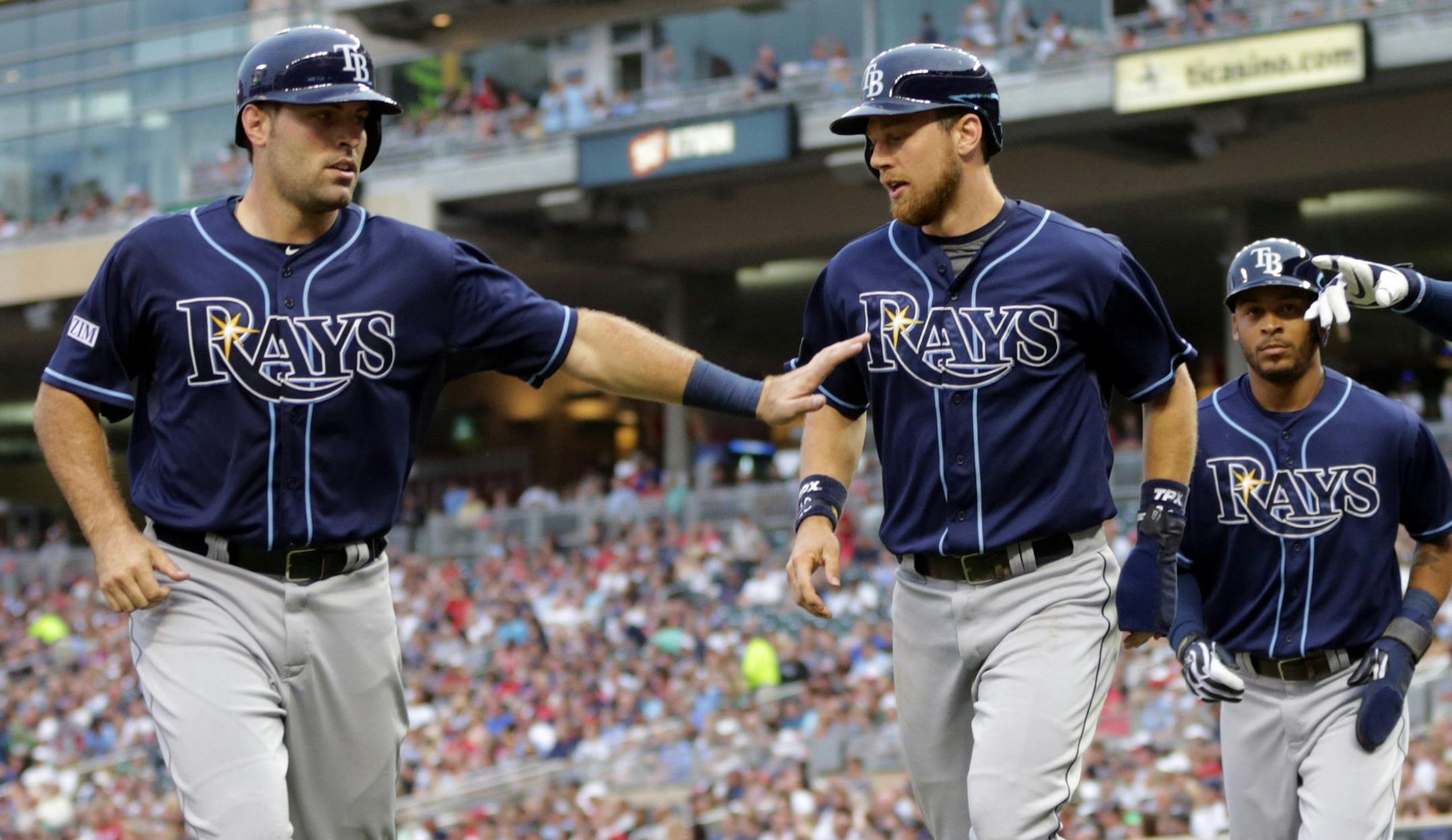Tampa Bays' Curt Casali, left, Ben Zobrist, center, and Desmond Jennings, right, score on a bases-loaded double by Evan Longoria off Minnesota Twins pitcher Kyle Gibson in the third inning of a baseball game, Friday, July 18, 2014, in Minneapolis. (AP Photo/Jim Mone) ORG XMIT: MNJM104