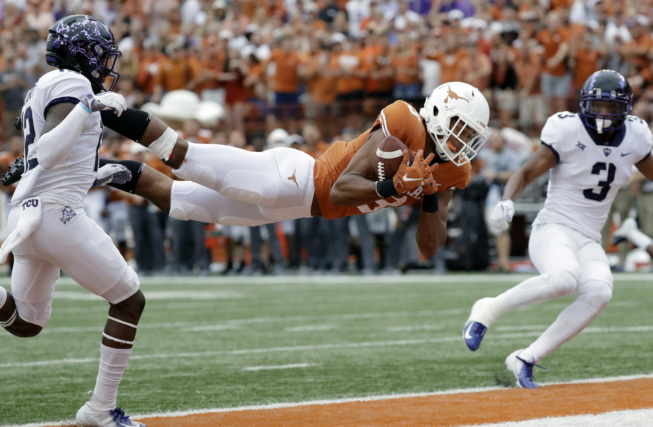 Texas wide receiver Collin Johnson (9) makes a diving catch for a touchdown between TCU defenders Jeff Gladney (12) and TCU safety Markell Simmons (3) during the second half of an NCAA college football game, Saturday, Sept. 22, 2018, in Austin, Texas. (AP Photo/Eric Gay)