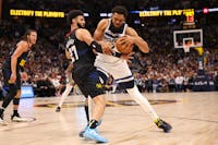 Minnesota Timberwolves' Karl-Anthony Towns (32) attempts to push past Jamal Murray of the Denver Nuggets during the first quarter in Game 2 of the NBA