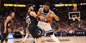Minnesota Timberwolves' Karl-Anthony Towns (32) attempts to push past Jamal Murray of the Denver Nuggets during the first quarter in Game 2 of the NBA