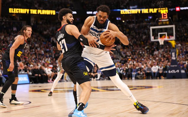 Minnesota Timberwolves' Karl-Anthony Towns (32) attempts to push past Jamal Murray of the Denver Nuggets during the first quarter on Monday. 