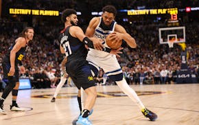Minnesota Timberwolves' Karl-Anthony Towns (32) attempts to push past Jamal Murray of the Denver Nuggets during the first quarter on Monday.