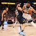 Minnesota Timberwolves' Karl-Anthony Towns (32) attempts to push past Jamal Murray of the Denver Nuggets during the first quarter on Monday. 